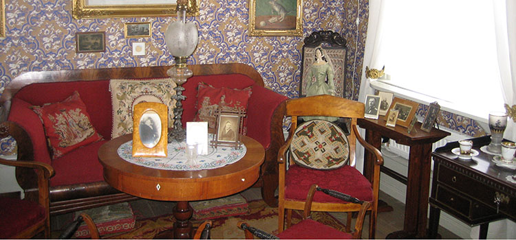 Bild inifrån museet - gammal fin soffa med tillhörande stol.