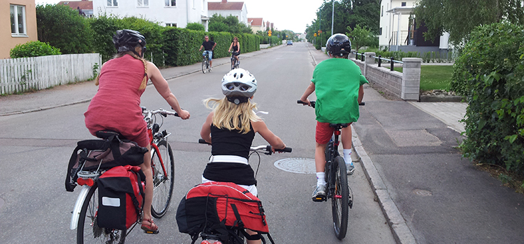 Trafiksäkerhet - Vuxna och barn som cyklar på en väg