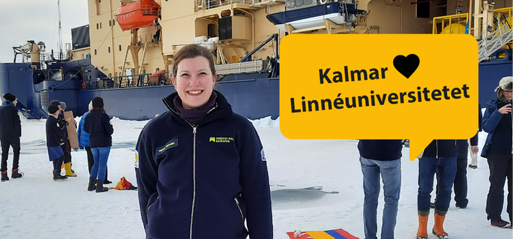 Hanna Farnelid står i centrum av bilden. Bakom sig har hon Oden, världens starkaste isbrytare. Delar av besättningen och forskargruppen syns också i bakgrunden. Det är snö på marken.